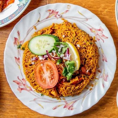 Spiced biryani rice with fresh cucumber, tomato, and lemon